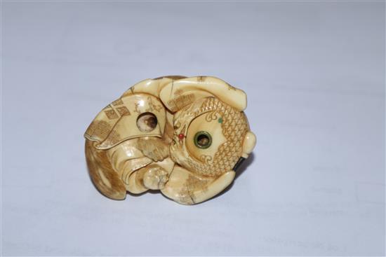 A Japanese Meiji period carved ivory netsuke of a fox cub on a cushion, with inset eyes 3.5cm high